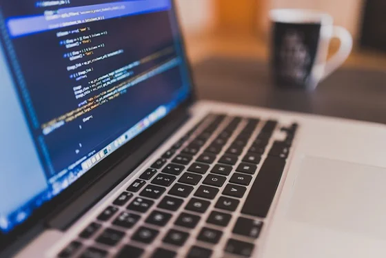 A developer working on code on a laptop